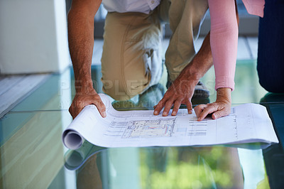 Buy stock photo Cropped view of a couple looking over plans on the floor