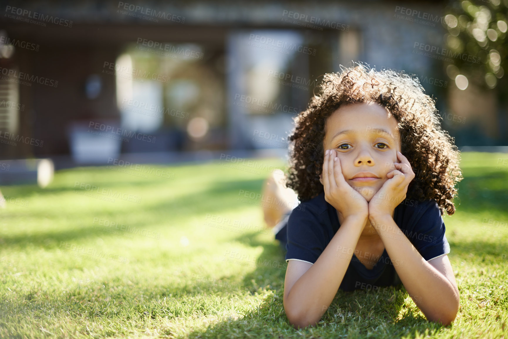 Buy stock photo Happy, nature and portrait of child in backyard relaxing on grass for development or fun in sunshine. Smile, sweet and cute boy kid laying on lawn in outdoor garden with positive attitude at home.