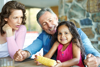 Buy stock photo A happy mature couple sitting with their young granddaughter