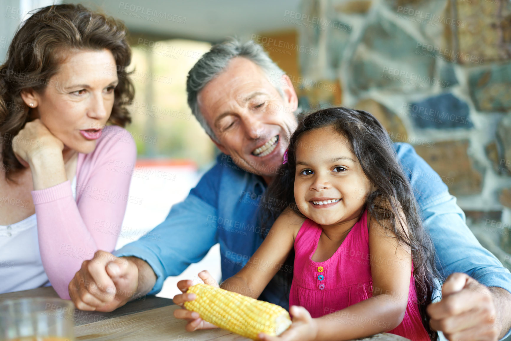 Buy stock photo A happy mature couple sitting with their young granddaughter