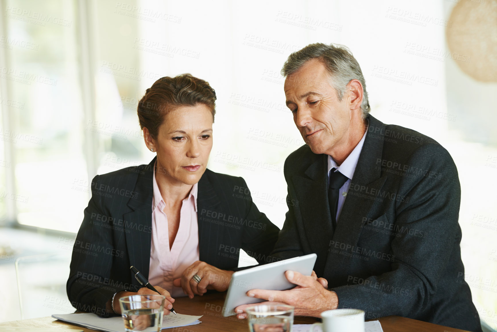 Buy stock photo Tablet, office and mature business people for meeting with internet research, collaboration and planning strategy together. Financial advisor job, man and woman by desk with tech and feedback notes