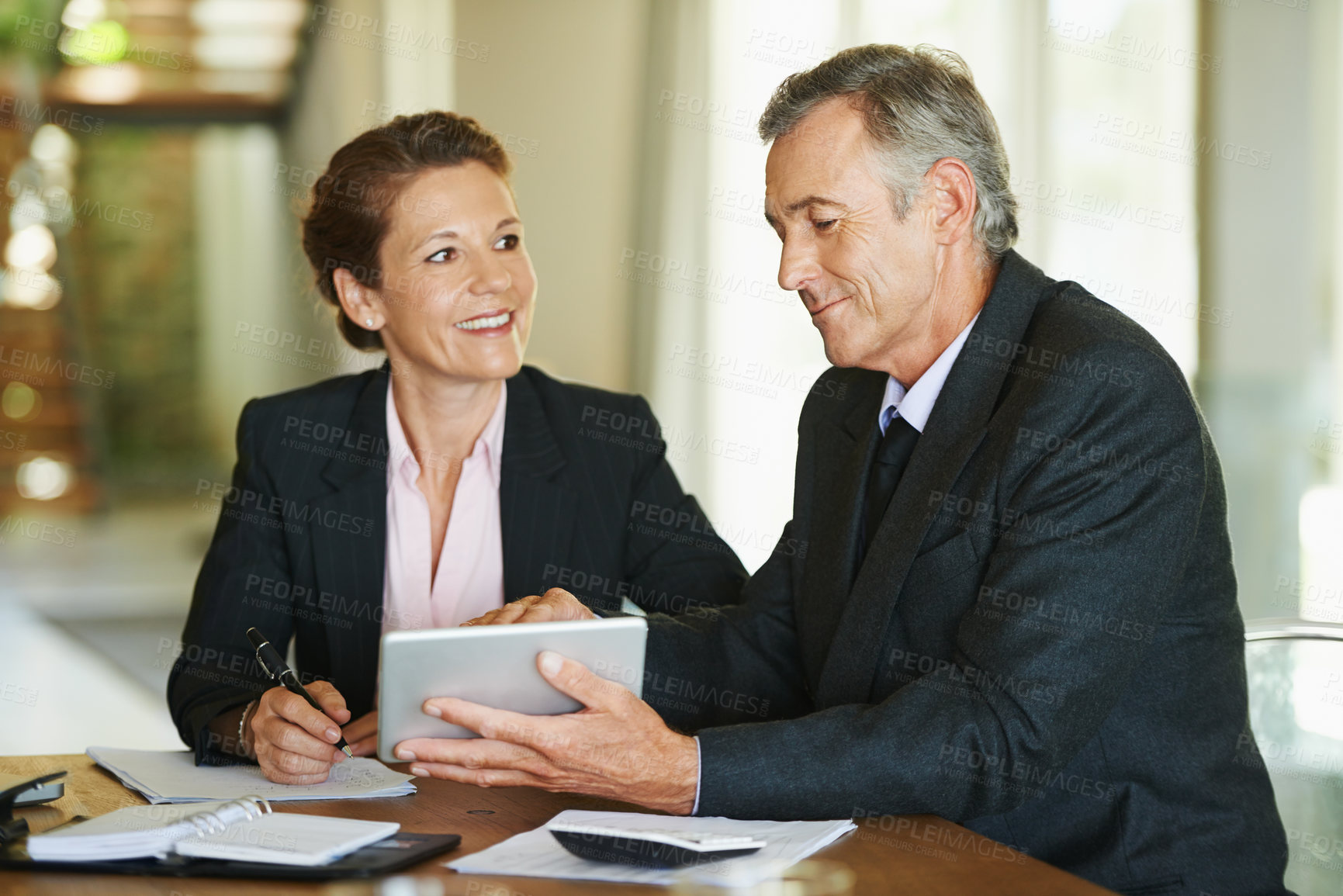 Buy stock photo Mature, businesspeople and tablet at desk with smile for ceo or manager of corporate company with pride. Technology, notes and paper with documents for accounting firm in Germany with client meeting.