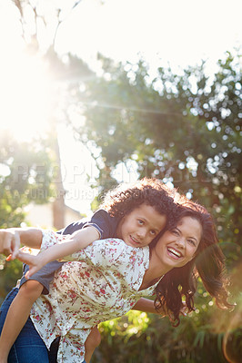 Buy stock photo A young mother piggybacking her son in the park