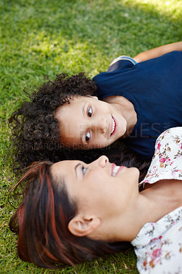 Buy stock photo A young mother and her son lying on the grass in the garden