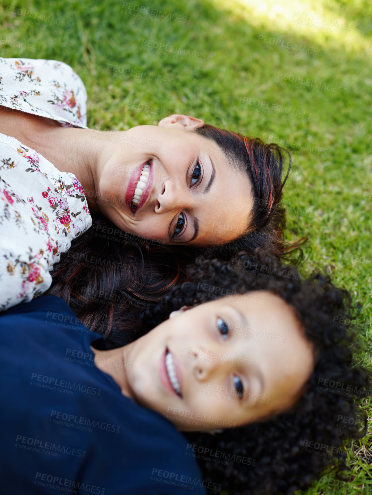 Buy stock photo A young mother and her son lying on the grass in the garden