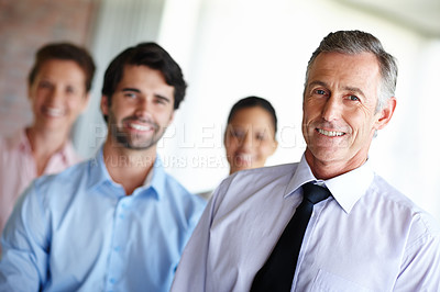 Buy stock photo A mature CEO leading his group of employees