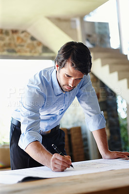 Buy stock photo A young architect doing the final corrections on a floor plan