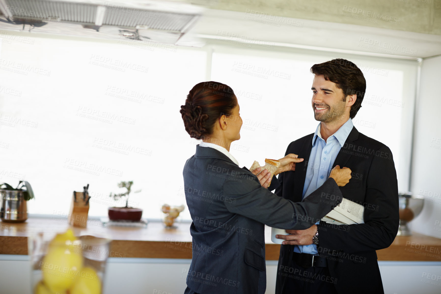 Buy stock photo Happy, man and woman helping with jacket for husband in kitchen before business meeting or presentation. Smile, couple and female person fixing suit for grooming, support and assistance at home