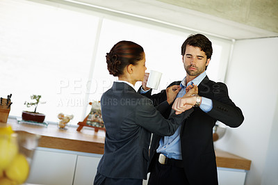 Buy stock photo Attractive woman fixes her husbands collar while he checks his watch