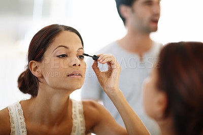 Buy stock photo Woman, mascara and makeup with mirror in bathroom for morning, grooming or getting ready at home. Young female person applying eyelash color, glow or cosmetics for beauty in reflection at house