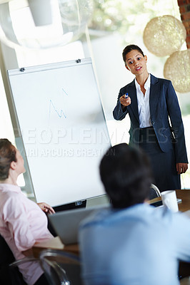 Buy stock photo An attractive young woman giving a business presentation to a group of colleagues