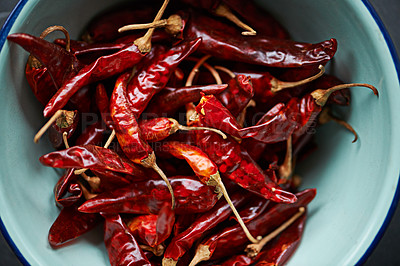 Buy stock photo Above, chilli and bowl on closeup for pepper or spice for flavor and dry ingredient for cooking, cuisine and food. Paprika, cayenne or condiment or spicy with red for capsicum or heat in dish or meal