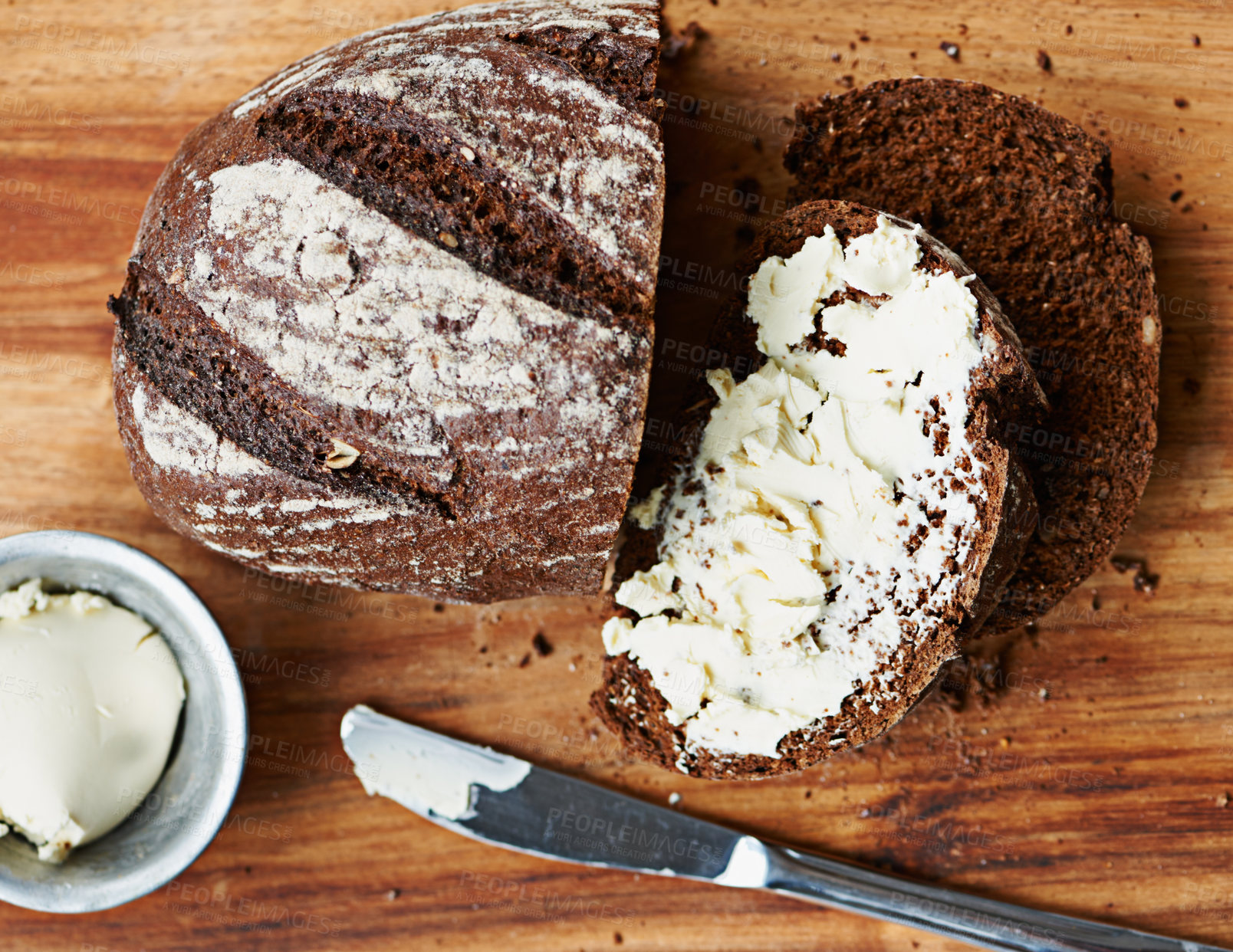 Buy stock photo Sourdough, bread and butter on slice for food, nutrition and carbs on kitchen table or fibre. Top view, wheat and rye snack on wooden board, grain and organic ingredients for artisan meal in home