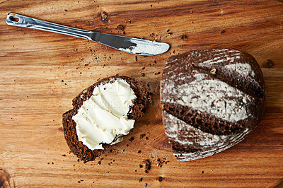 Buy stock photo Sourdough, bread and butter on slice for meal, nutrition and carbs on kitchen table or fibre. Top view, wheat and rye snack on cutting board, grain and organic ingredients for artisan food in home