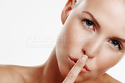 Buy stock photo Beauty shot of a young blonde woman with her finger on her lips