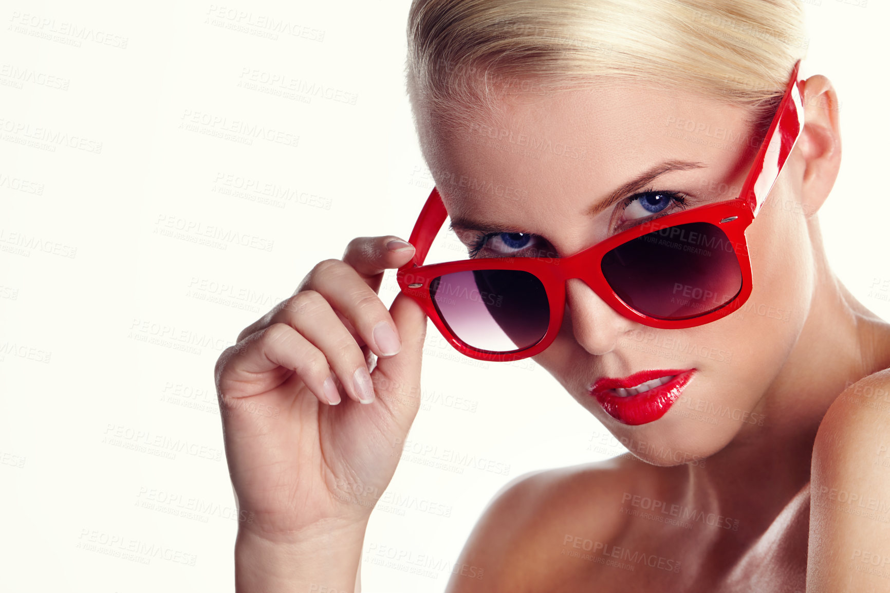 Buy stock photo Portrait of a beautiful woman wearing red lipstick and peeking over her red sunglasses