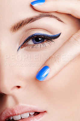 Buy stock photo Close up of a blue eye with blue eyeliner with two fingers with blue nailpolish on
