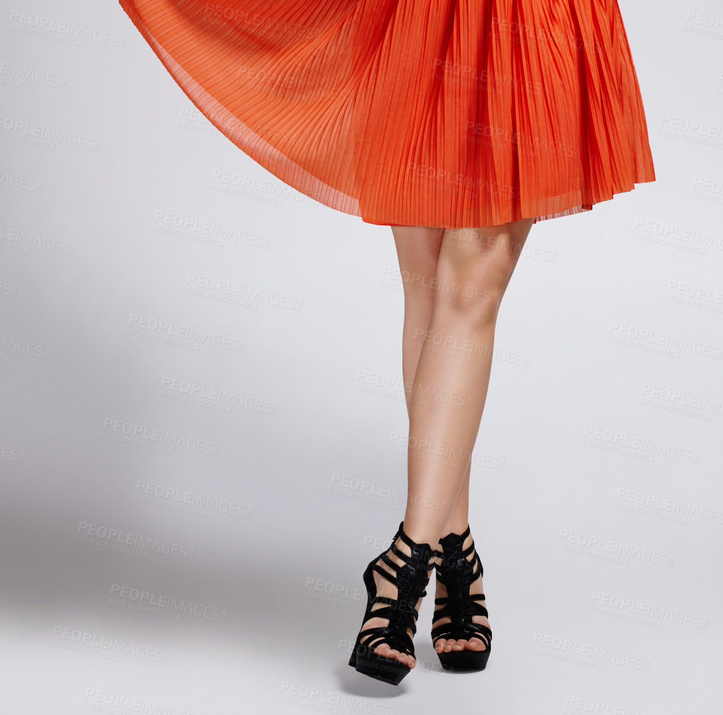 Buy stock photo Waist down studio shot of a woman in an orange dress and high heels