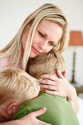Buy stock photo An upset mother hugging her two sons