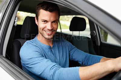 Buy stock photo Attractive male sitting in his car looking at the camera with his hands on the steering wheel