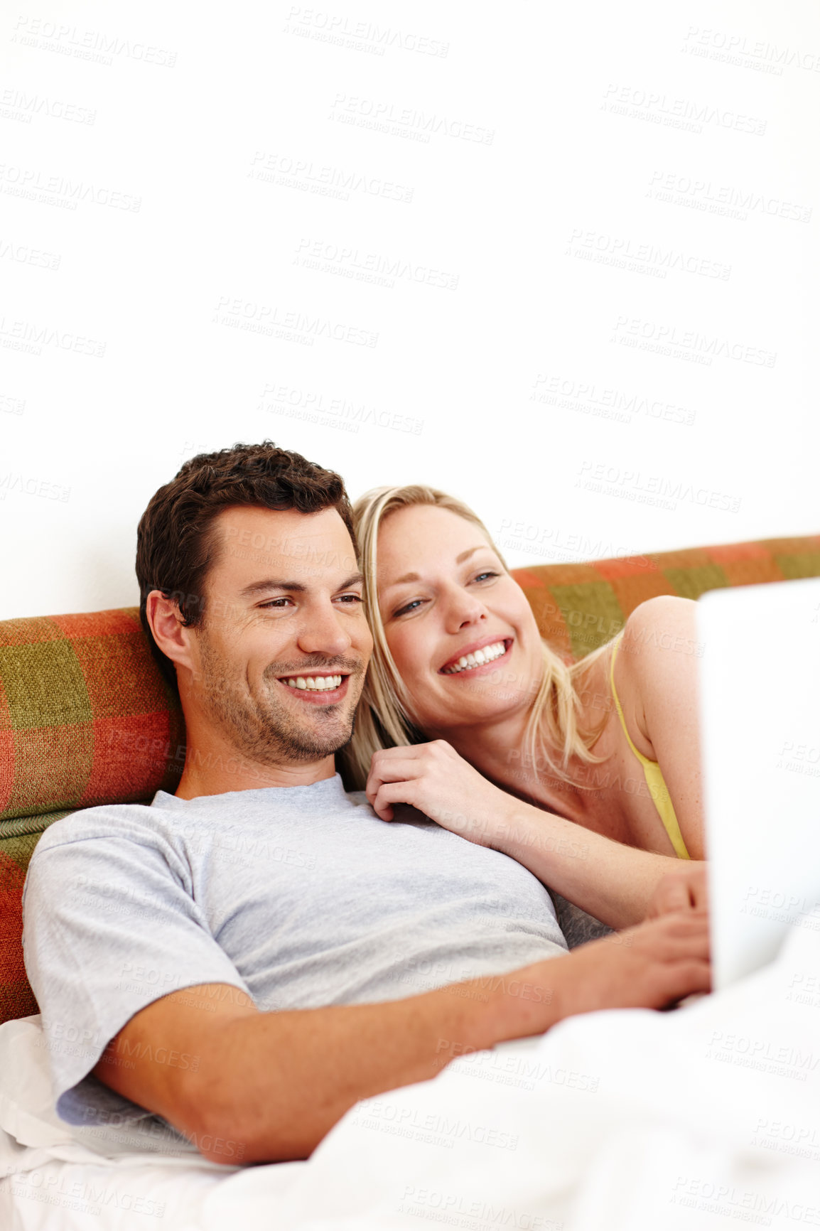 Buy stock photo Couple, laptop and morning in bed in home with laughing for social media meme, internet browsing or relax. People, technology or happy in bedroom with bonding, affection or watching movie with mockup
