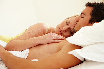Buy stock photo A loving young couple asleep in bed together at home