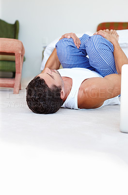 Buy stock photo Morning, man and lying on floor for wake up, wellness and stretch or yoga in bedroom. Comfortable, peace and male person on weekend for exercise and spinal twist for flexibility or movement in home