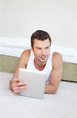 Buy stock photo Thinking, tablet and man on floor for social media, online shopping and internet in bedroom. Relax, resting and person on digital tech for reading website, news blog and research on weekend at home