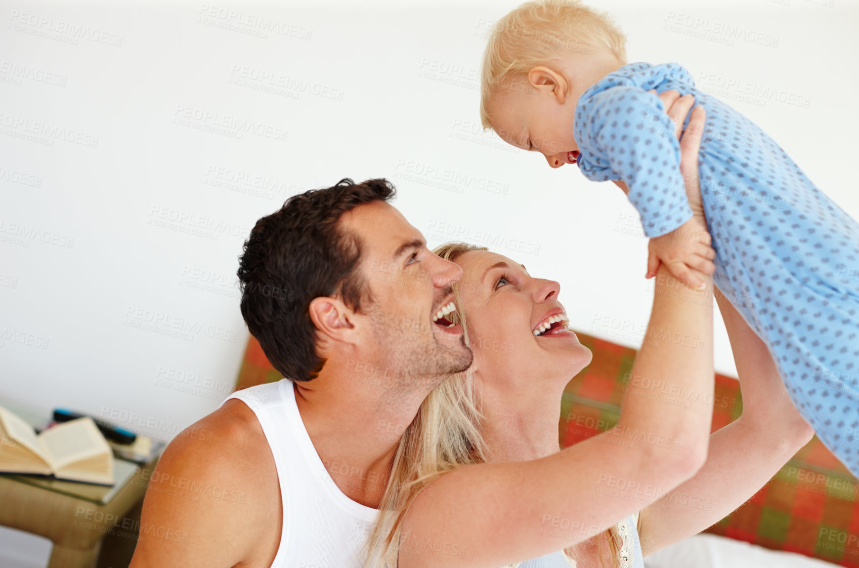 Buy stock photo Love, support or parents lifting baby in bedroom with fun, bonding and playing morning games at home together. Family, learning or people in house with security, trust or care for child development