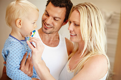 Buy stock photo A young mother and father brushing their little boy's teeth