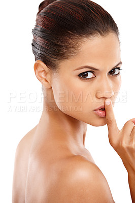 Buy stock photo Attractive young woman with her finger on her lips against a white background