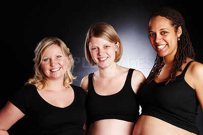 Buy stock photo Portrait, women and pregnancy in studio for wellness, support and smile or pride for friends. Diversity, community and mothers by black background for growth, development and happiness for maternity