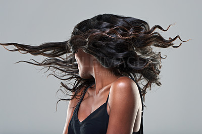 Buy stock photo Studio shot of a young woman with beautiful hair isolated on gray