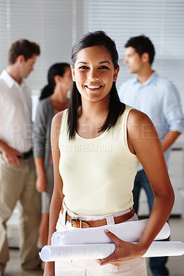 Buy stock photo Portrait of a beautiful young woman holding blueprints and smiling at you