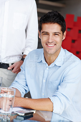 Buy stock photo Portrait of a confident young businessman sitting at the boardroom table