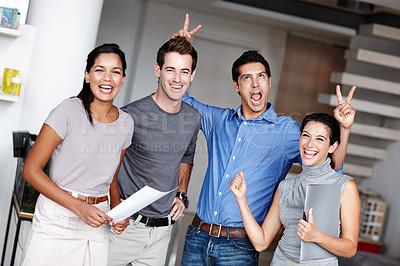 Buy stock photo A comedic businessman pulling bunny ears on two of his colleagues in the office