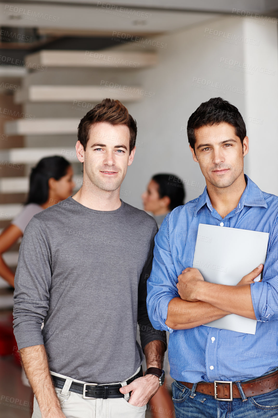 Buy stock photo Portrait of two creative associates standing together in the office following a successful meeting
