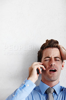 Buy stock photo A young businessman taking a devastating call while standing below copyspace