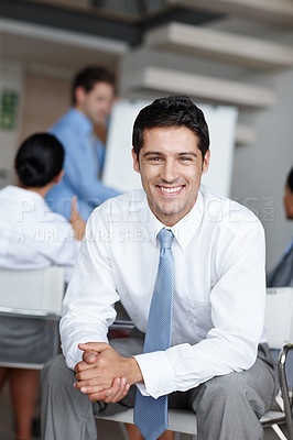 Buy stock photo A young business executive smiling at you confidently with clasped hands