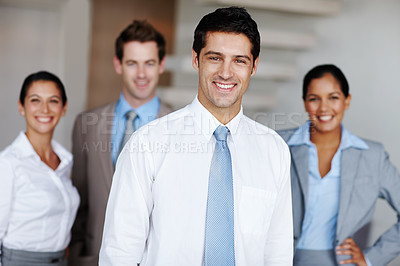 Buy stock photo A young business leader standing in front of his team smiling confidently