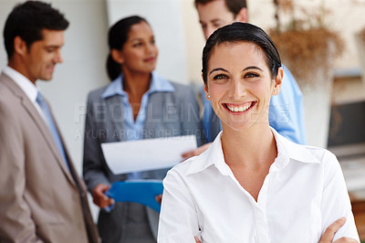 Buy stock photo Portrait of a beautiful young businesswoman with her colleagues blurred in the background