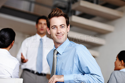 Buy stock photo A handsome young businessman turning to look at you during a business presentation