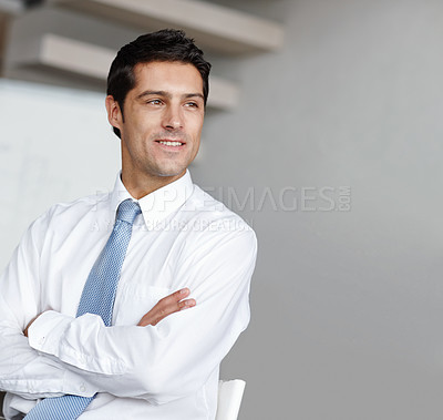 Buy stock photo A handsome young businessman crossing his arms and looking away thoughtfully
