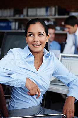 Buy stock photo A pretty young businesswoman looking away thoughtfully while sitting at her workspace