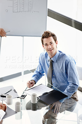 Buy stock photo A confident businessman sitting at the boardroom table during a presentation