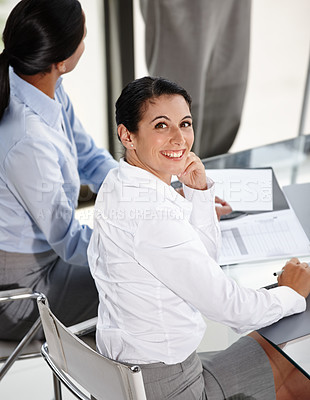 Buy stock photo A pretty businesswoman glancing over her shoulder at you while attending a presentation in the boardroom
