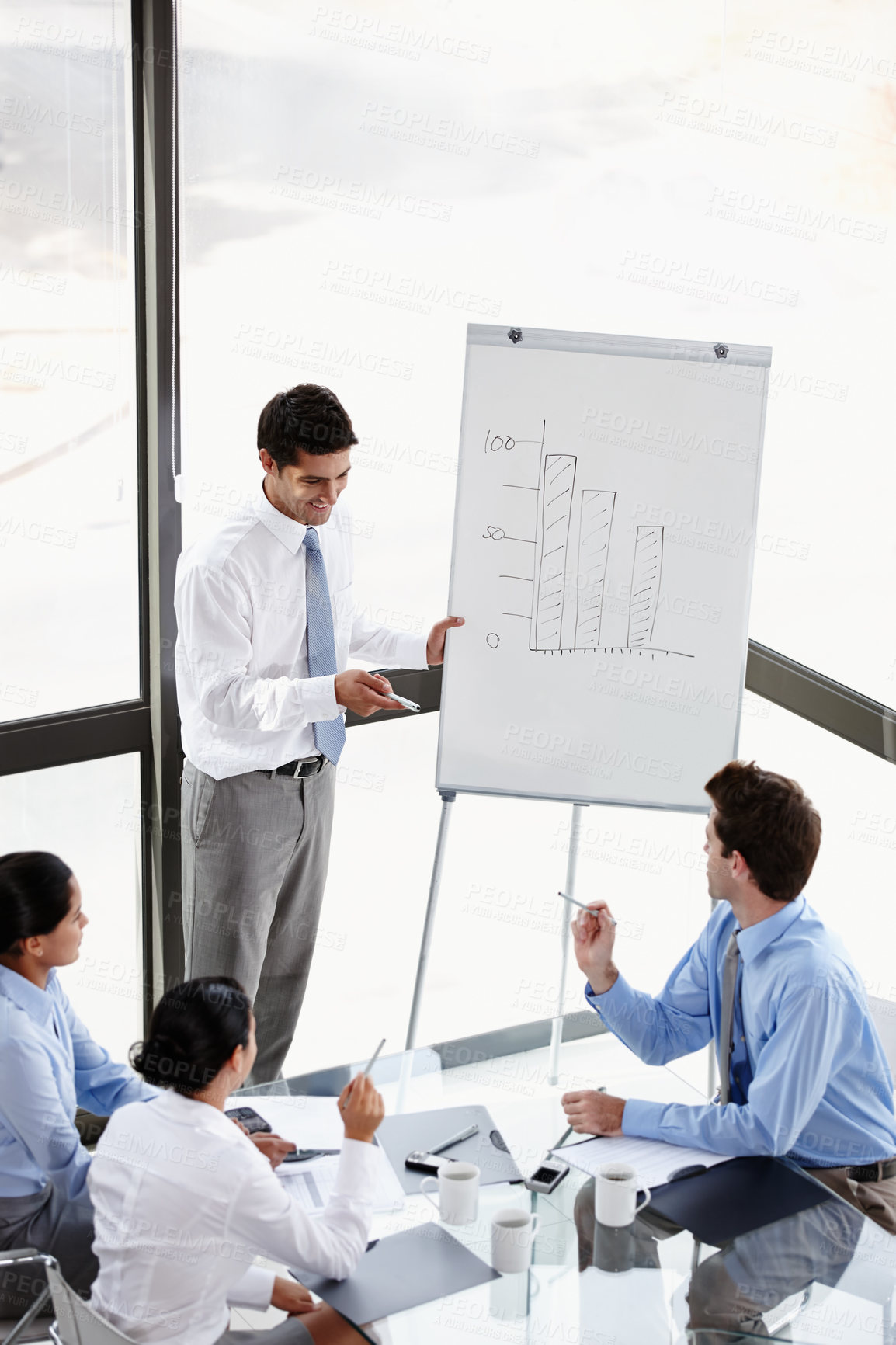 Buy stock photo A young businessman presenting to his colleagues in the boardroom