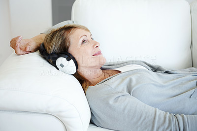 Buy stock photo Mature woman, headphones and smile on sofa in home, living room and relax with listening to radio. Person, music and subscription for audio book, happy and streaming with memory on couch in Germany