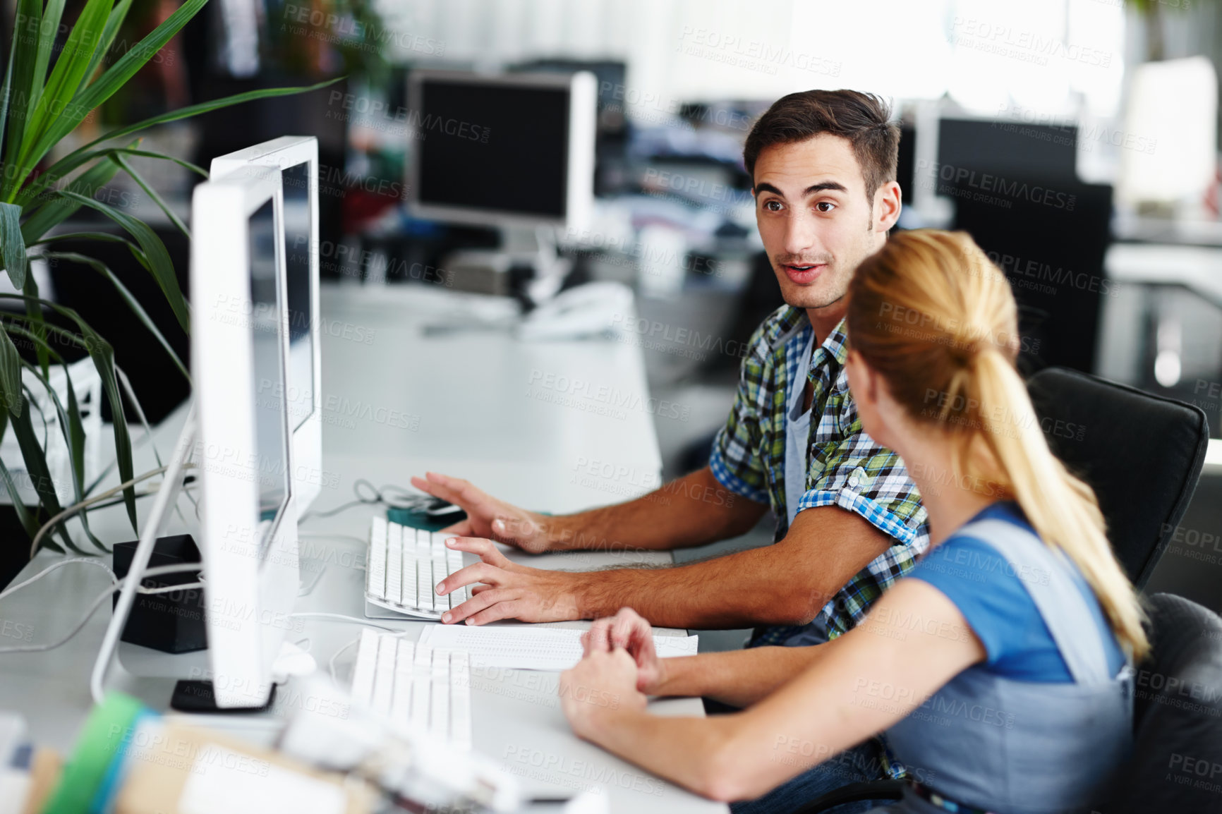 Buy stock photo Two colleagues working on a computer together