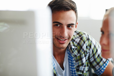 Buy stock photo Two colleagues working on a computer together